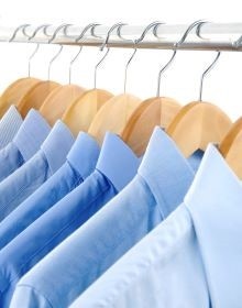 koszule w r&oacute;żnych odcieniach koloru niebieskiego wiszą na wieszaku